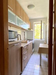 cocina con armarios de madera, fregadero y ventana en Apartament Myria en Constanza