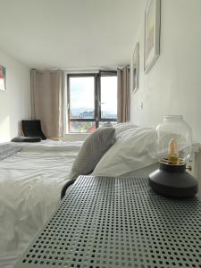 a white bedroom with a bed and a window at Penthouse Apartment w/ Parking in Sheffield