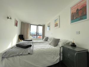 a bedroom with a white bed and a television at Penthouse Apartment w/ Parking in Sheffield