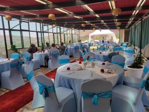 Debre ZeyitIvy Hotel, Bishoftu的宴会厅配有白色桌子和蓝色弓