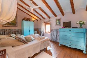 Vilardida的住宿－Les Vinyes Alojamiento Rural Boutique & SPA，一间卧室配有蓝色梳妆台和一张床