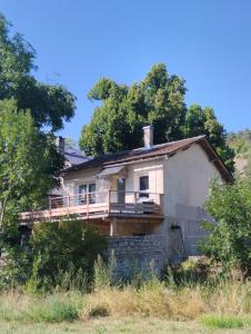una casa antigua con porche en una colina en La dépendance du vieux tilleul- Gorges Tarn et Jonte, en Meyrueis