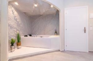 a white bathroom with a sink in a room at IOSIF suites in Neos Marmaras