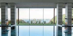 a room with a large window with a view at Lefay Resort & Spa Lago Di Garda in Gargnano