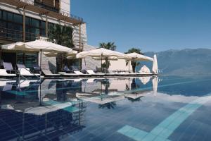 een zwembad met stoelen en parasols in een hotel bij Lefay Resort & Spa Lago Di Garda in Gargnano