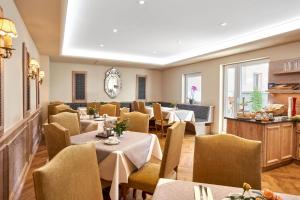 a restaurant with tables and chairs in a room at Hotel Kraft in Munich