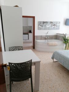 La salle de bains est pourvue d'une baignoire, d'une table et d'une chaise. dans l'établissement Casa rosa Abruzzo 3, à Musellaro