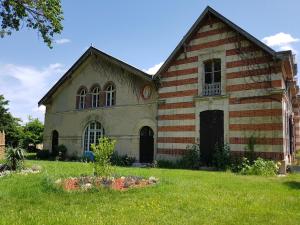 Villers-Allerand的住宿－La Bastide Champenoise - Chambres d'hôtes，一座古老的教堂,前面有一个草地庭院