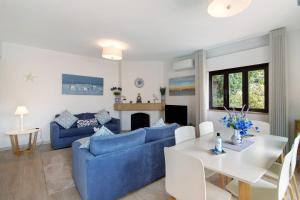 a living room with a blue couch and a table at Casa Harlequin in Vale do Lobo
