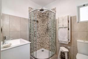 a bathroom with a shower and a sink and a toilet at Casa Harlequin in Vale do Lobo +16 photos