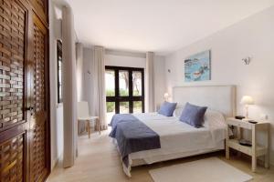a bedroom with a bed with blue pillows at Casa Harlequin in Vale do Lobo