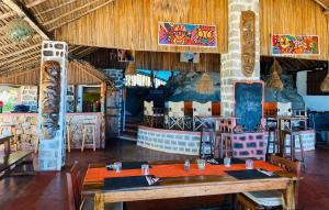 un ristorante con un grande tavolo in legno in una stanza di Tamarin Lodge ad Ampangorinana