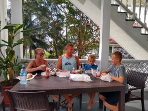 a family sitting at a table on a porch at The Great House Inn in Belize City
