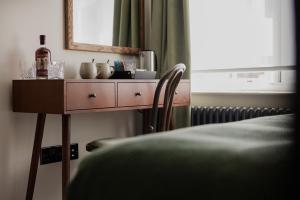 a dresser with a mirror and a chair in a room at The George & Dragon in Westerham