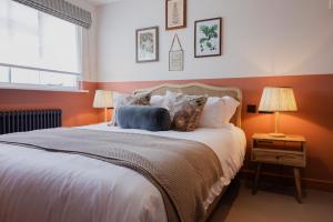 sypialnia z dużym łóżkiem z pomarańczowymi ścianami w obiekcie The George & Dragon w mieście Westerham