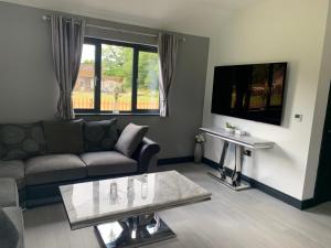 a living room with a couch and a table at Belvedare-Suffolk in Sudbury