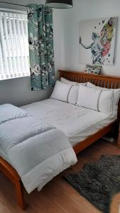 a bedroom with a large bed with white sheets at 2 bedroom Chalet all to yourself, free parking, dogs welcome in Swansea