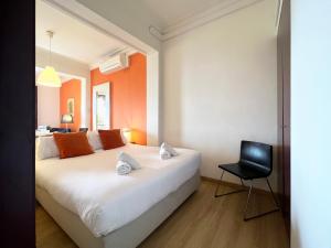 a bedroom with a white bed and a black chair at Stay U-nique Apartments Colom in Barcelona