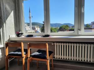 2 sillas sentadas frente a una ventana con vistas en Apartman Tvrdjava, en Banja Luka