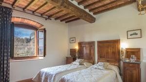 a bedroom with two beds and a window at Casale Presciano in Pergine Valdarno