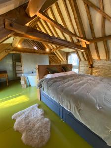 um quarto com uma cama e um tapete no sótão em The Hayloft em Stonehouse