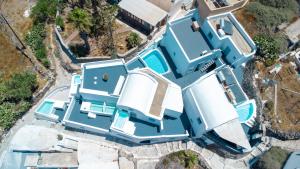 an overhead view of a blue house with a swimming pool at White Cave Villas in Oia