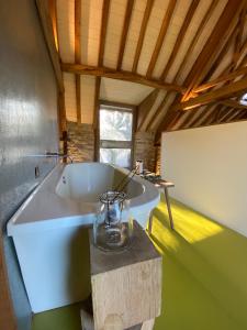 a large white bath tub sitting in a room at The Hayloft in Stonehouse