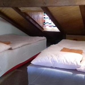 two beds in a attic room with a window at Holiday Home Jakovci in Netretić