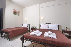 a bedroom with two beds and towels on a bed at AVRA STUDIOS in Paliouri