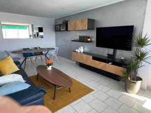 a living room with a blue couch and a flat screen tv at La Goélette ou Souléou front de mer 3étoiles appartement 2 chambres in Toulon