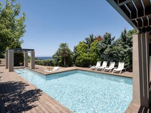a swimming pool with two chairs and a table at Elafonisi Villas in Livadia