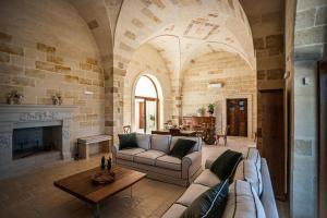 a living room with a couch and a fireplace at Masseria Torleanzi Wine Relais in San Pietro Vernotico