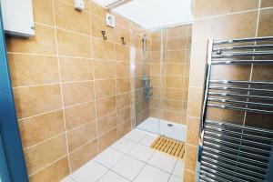 a bathroom with a shower with brown tiles at Allercombe Farm Glamping Yurts & Wild Camping in South Brent