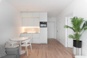 eine Küche und ein Wohnzimmer mit einem Tisch und einer Pflanze in der Unterkunft Brand New and Modern 1BDR Apartment in Vilnius