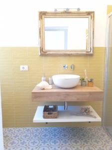 La salle de bains est pourvue d'un lavabo et d'un miroir. dans l'établissement Dimora Quattro Vanelle, à Favignana
