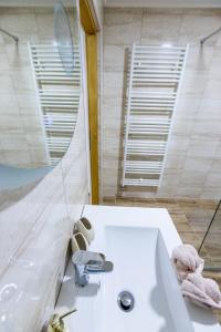 ein Badezimmer mit einem weißen Waschbecken und einem Spiegel in der Unterkunft Apartmani Tomšić in Darda
