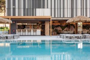 una piscina con mesas y sombrillas en un edificio en Hotel Primavera Park, en Benidorm