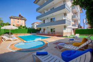 un gran edificio con piscina y algunas sillas en AZAK BLUE OTEL en Okurcalar