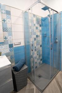 Tyche apartaments & rooms في تاورمينا: حمام به دش وبه بلاط ازرق