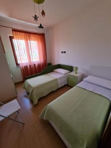 1 dormitorio con 2 camas y ventana en Diamante 46, Appartamento per vacanza en Diamante