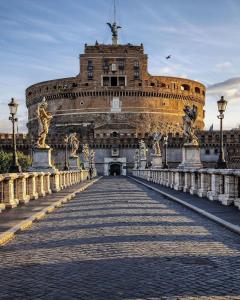 a large building with a bridge in front of it at Saint Peter Cozy Apartment in Rome