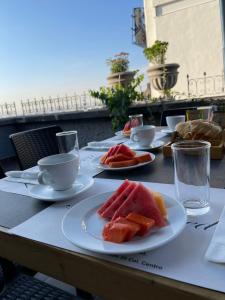 a table with plates of watermelon and cups on it at Hotel Catedral in Mexico City