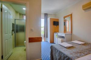 a hotel room with a bed and a bathroom at AZAK BLUE OTEL in Okurcalar