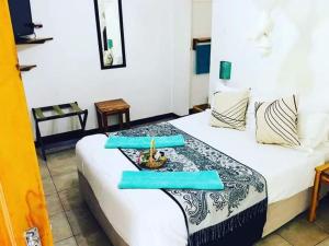 1 dormitorio con 1 cama con 2 toallas azules en Green Tree Lodge, en Livingstone