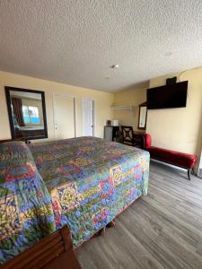 a hotel room with a bed and a flat screen tv at Walden Motel in Las Vegas