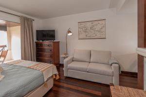 una camera con letto, divano e TV di Atrium Studio Cascais a Cascais