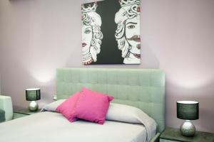 Tyche apartaments & rooms في تاورمينا: غرفة نوم بسرير ومخدة وردية