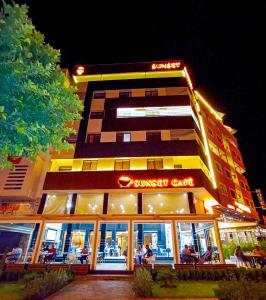 a building with a restaurant in front of it at night at Hotel SunSet Beni Mellal in Beni Mellal