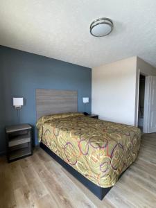 a bedroom with a bed in a room with a lamp at Garden Inn & Suites in Hogansville