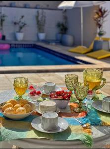 a table with food and drinks and a swimming pool at CASA ALUNAI in Pirenópolis +21 photos